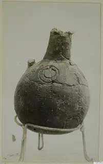 Red Polished III jug from Lapithos, Vrysi tou Barba tombs, shown on a wire stand against a plain background