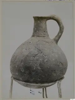 Red Polished III jug from Lapithos, Vrysi tou Barba tombs, shown on a wire stand