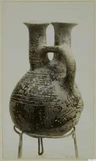 Pottery Red Polished II Jug from the Vrysi tou Barba tombs at Lapithos, with two necks and a strap handle
