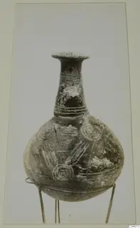 Pottery Black Polished vessel with a long neck, flared rim and incised circle decoration, standing on a wire stand