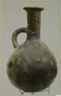 Pottery Red Polished III jug from Lapithos, with a single loop handle and a flared rim