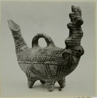 Painted clay bird-shaped vessel with a long spout, a handle and three legs, decorated with dark bands and cross-hatching.