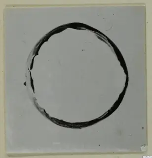 Dark ring-shaped object centred on a pale plain ground, a find from the Kastros tombs at Lapithos.