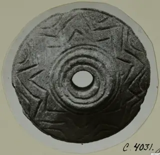 Disc-shaped stone object with a central hole, concentric ridges and incised star-like patterns, from Idalion