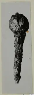 Corroded bronze object with a rounded head and long tapering shaft, from Idalion