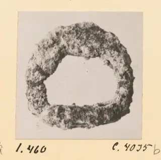 Corroded metal ring from Idalion, shown face-on against a pale grey backdrop.