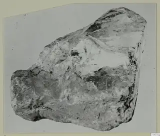 Irregular grey and white stone fragment from Idalion, shown against a pale background