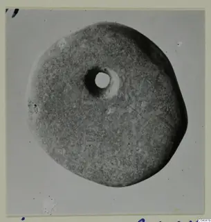 Flat round disc with a central hole, photographed on a grey background