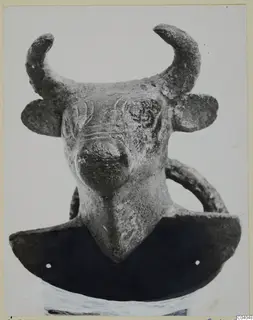 Bull's head with curved horns and a ring handle, from Idalion, on a dark curved base