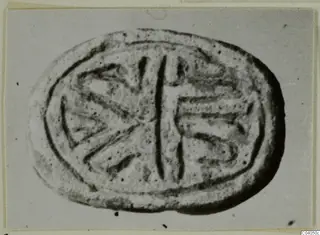 Oval stone seal with an incised design of a central vertical line and radiating lines on each side