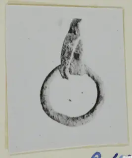 Bronze loop with a flattened, broken projection rising from its upper edge, photographed on a card mount