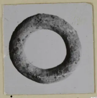 Bronze ring-shaped personal adornment, shown as a photograph on a white card