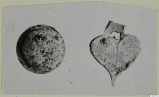 Bronze mountings from Idalion: a round disc and a heart-shaped fragment with a tab, shown side by side
