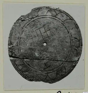 Round flat disc with a central hole and incised grid and arc decoration, from Enkomi Tomb 6, on a mounted card