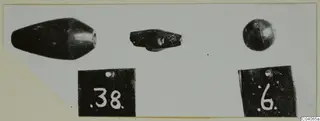 Three small dark objects on a white card, with two black number labels below them.