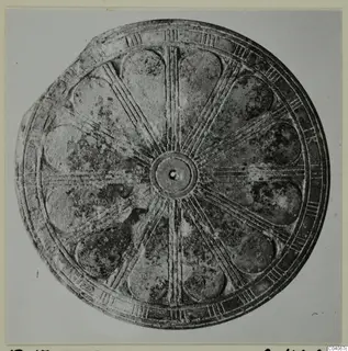 Round metal disc with radiating ribs, petal-shaped panels and a central boss, from Enkomi Tomb 17