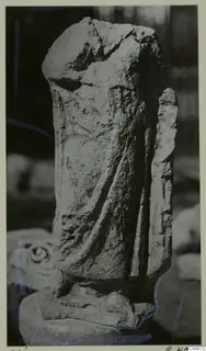 Weathered limestone sculpture of a draped standing figure from Mersinaki, head broken away