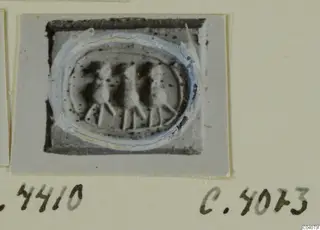 Oval engraved stone from Ayia Irini, with three upright figures standing in a row across its centre