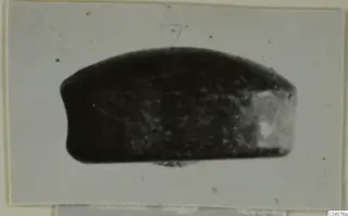Glyptic A.I.2296, a small dark oval seal or gem photographed on a pale card