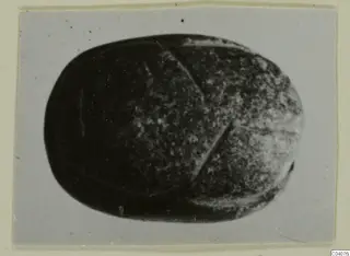 Scarab-shaped gem from Ayia Irini, photographed close up on a grey card.