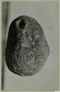 Egg-shaped object with a hole near its top, photographed against a pale background