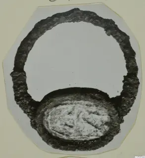 Finger ring with an oval bezel engraved with a figure, from Marion, photographed on a mounted card.