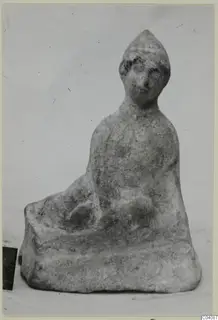 Seated terracotta figurine from Marion with a tall pointed head and a rounded body.