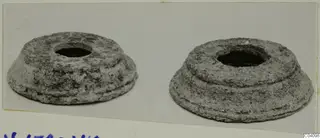 Two encrusted, stepped mounts with central holes, placed side by side on a card.