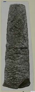 Corroded metal implement from Arsos, long and tapering, shown upright on a card mount.
