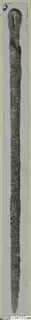 Long, narrow corroded metal object with a looped top end and tapering point, from Arsos