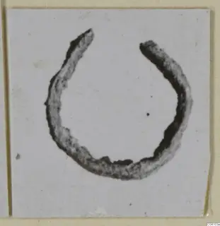 Open bronze ring, corroded, shown on a white card, from Arsos