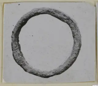 Corroded metal ring from Arsos, shown on a card mount.