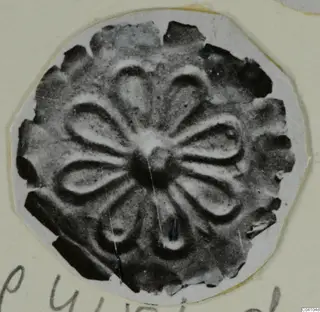 Disc-shaped piece of jewellery with a petal pattern around a central boss, from Arsos