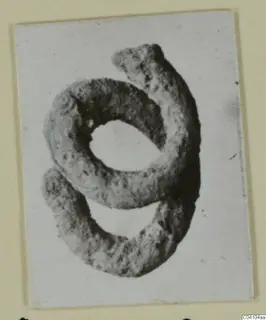 Coiled metal jewellery from Arsos, an open spiral with a rough, pitted surface