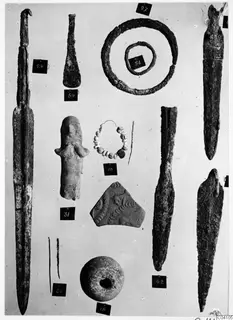 Bronze weapons, tools and small finds from Ayios Iakovos Tomb 14, laid out on a pale background with numbered labels.
