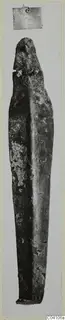 Bronze tool from Ayios Iakovos, long and narrow, photographed upright with a corroded green-brown surface