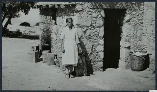 Eleni standing in front of the stone kitchen building at Vouni