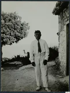 Sofoklis, known as Mavrokeratas, digger at Vouni Palace, standing beside a stone building on a dirt track
