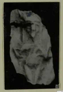 Irregular pale fragment from Amathus tombs, photographed against a black background; the material is hard to make out.