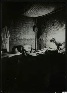 Interior of a bast house at Mersinaki with woven reed walls, a table, chair and hanging hat