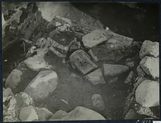 Finds in situ at Cholades, Soli: a carved stone head lying in the soil among blocks and rubble