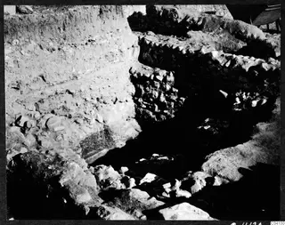 Excavation at Cholades, Soli, with a soil section and stone walls in a trench