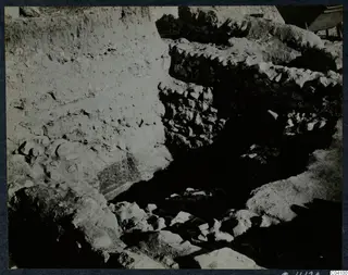 Excavation at Cholades, Soli, showing a stone-walled trench and a steep soil face