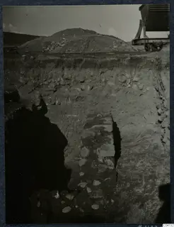 Excavation trench at Soli with a line of stones in the cut and a rail-mounted cart at upper right