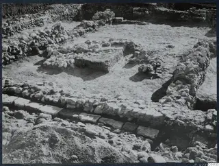 Excavation at Soli showing low stone walls and a stone-built platform in a cleared area