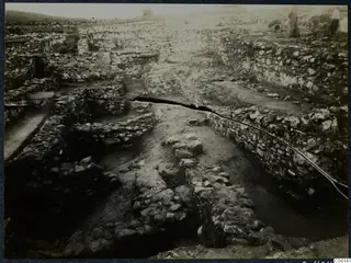 Excavated stone walls at Soli, Cholades Temples C-F, with several people standing at the upper right edge