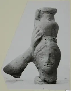 Terracotta figurine with a modelled human face, a tubular projection on the left and a small base