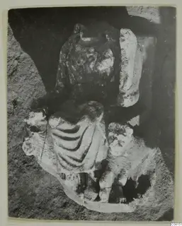 Fragmentary stone sculpture of a draped figure from Soli, photographed in a dark recess.