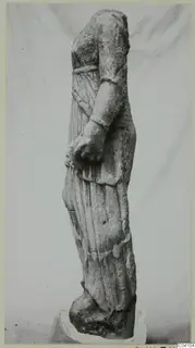 Stone statue of a draped standing figure from Soli, head and part of the arms missing.