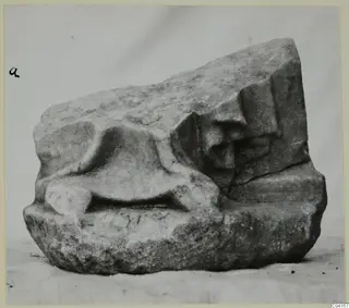 Marble sculpture fragment with a rounded raised form in the centre and a carved stepped profile on the right
